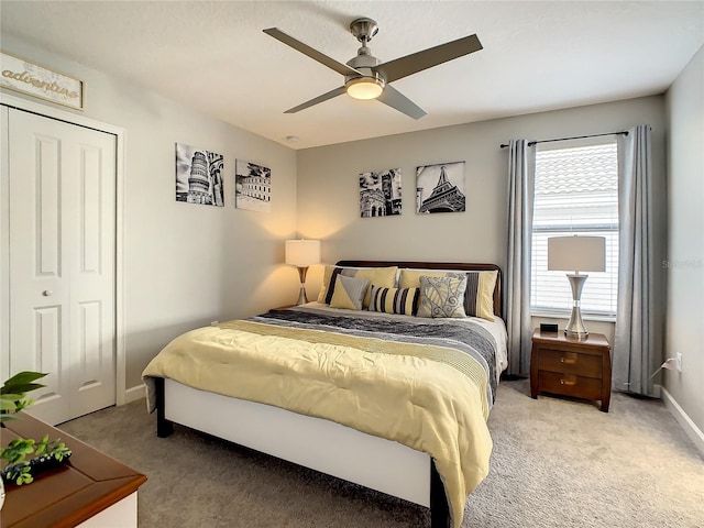 bedroom featuring ceiling fan, a closet, and light colored carpet