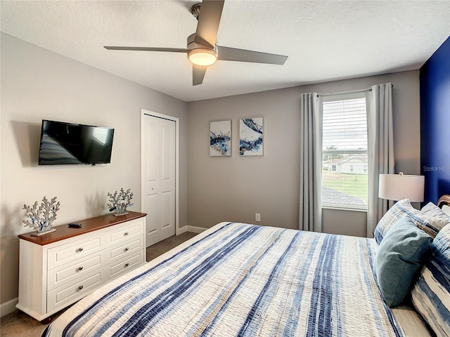 carpeted bedroom with ceiling fan and a closet