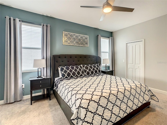 carpeted bedroom featuring a closet, multiple windows, and ceiling fan