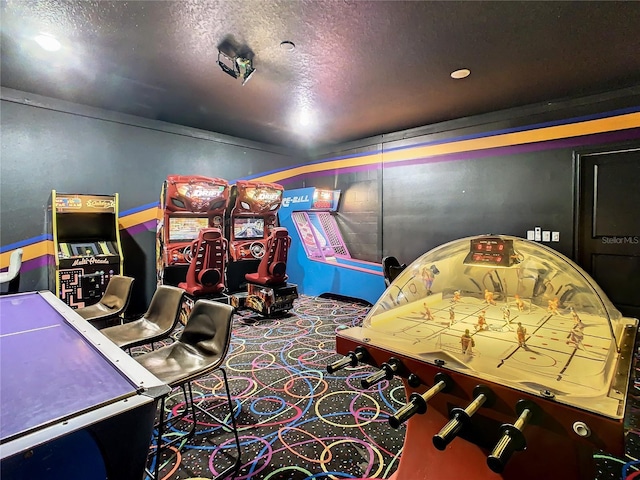 recreation room featuring carpet flooring and a textured ceiling