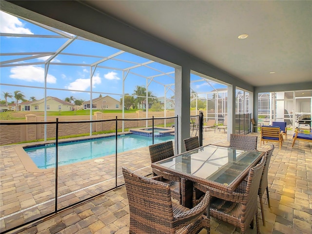 view of pool with glass enclosure, an in ground hot tub, and a patio area