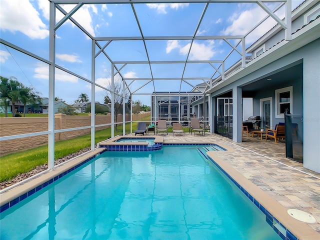 view of pool featuring glass enclosure, an in ground hot tub, and a patio