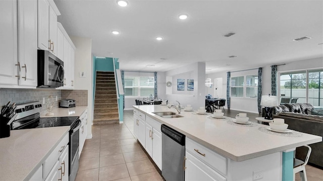 kitchen featuring white cabinetry, a kitchen island with sink, sink, and stainless steel appliances