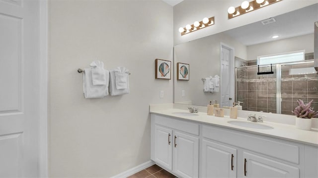 bathroom featuring tile patterned floors, a shower with door, and vanity