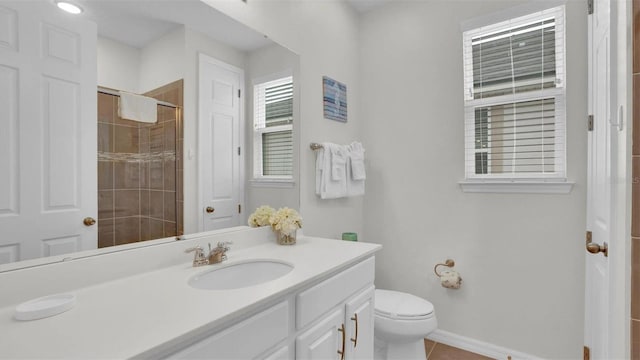 bathroom with tile patterned flooring, vanity, toilet, and walk in shower