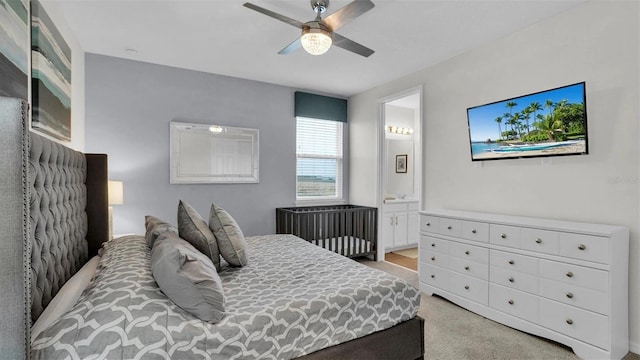 bedroom featuring connected bathroom, ceiling fan, and light carpet