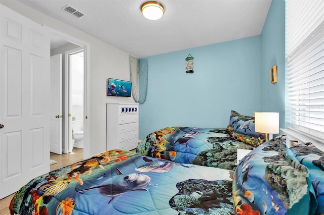 bedroom with a textured ceiling and ensuite bathroom