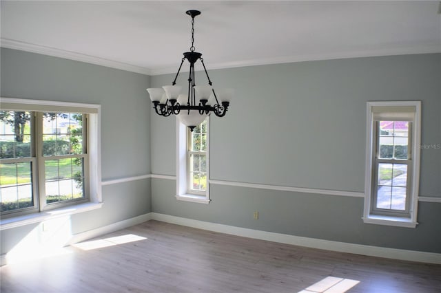 unfurnished room featuring a chandelier, a wealth of natural light, and wood-type flooring