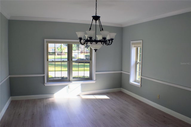 empty room featuring crown molding, a healthy amount of sunlight, and wood-type flooring