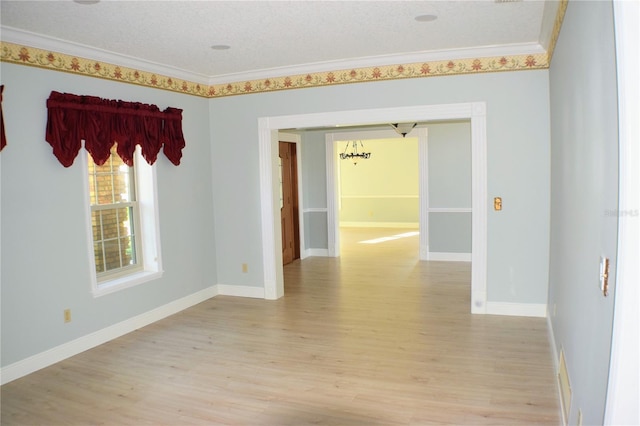 unfurnished room with a textured ceiling, light hardwood / wood-style flooring, and ornamental molding