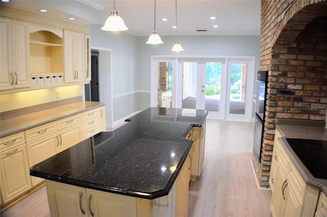 kitchen featuring pendant lighting, french doors, light hardwood / wood-style flooring, black electric cooktop, and a kitchen island