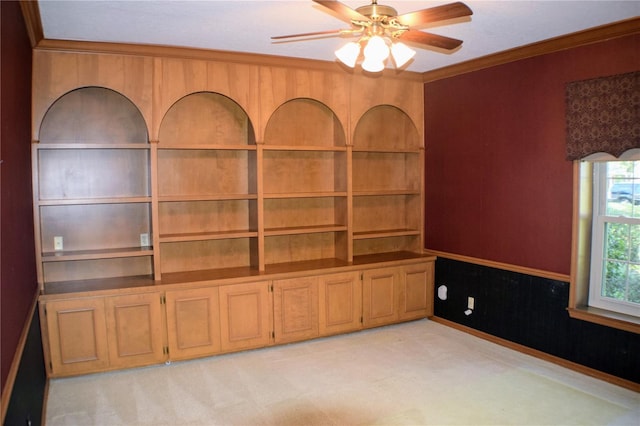 unfurnished room with ceiling fan, crown molding, and light carpet