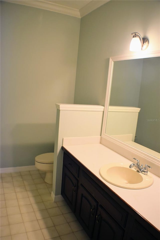 bathroom featuring tile patterned floors, vanity, toilet, and crown molding