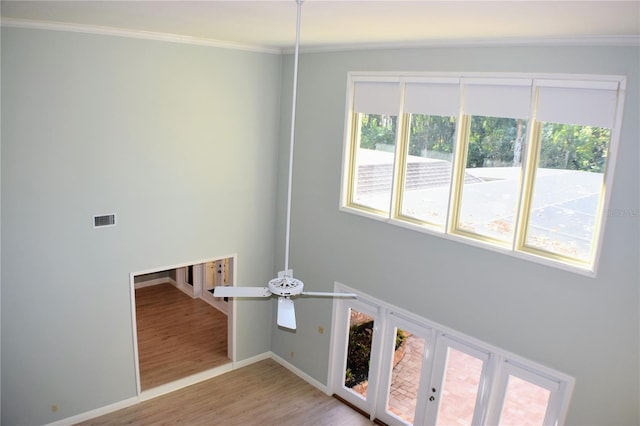 clothes washing area with light hardwood / wood-style flooring, ceiling fan, and crown molding