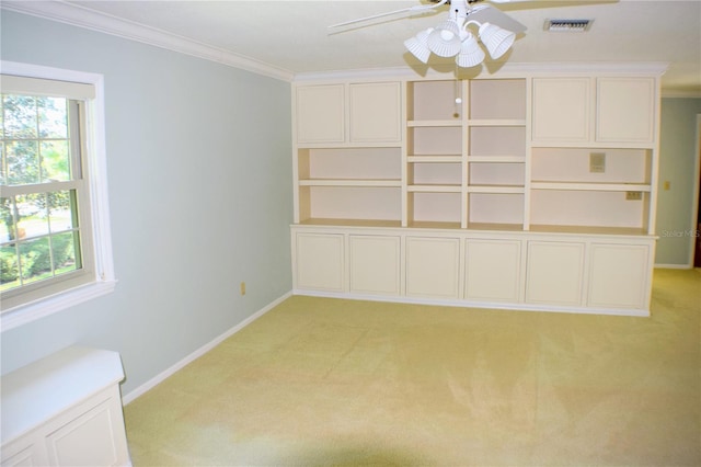 carpeted spare room with plenty of natural light, ceiling fan, and ornamental molding