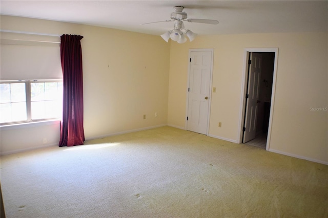 carpeted spare room featuring ceiling fan