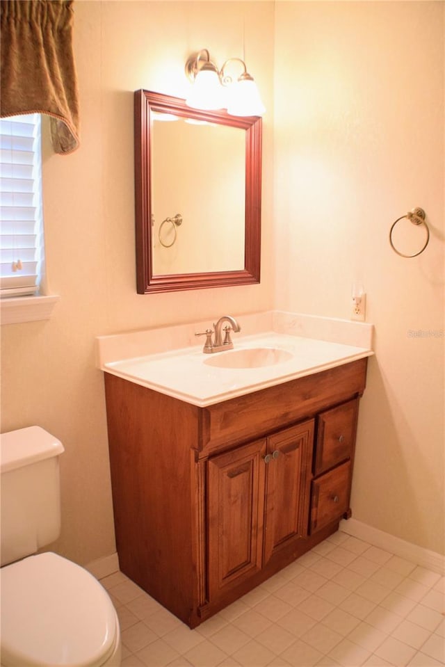 bathroom featuring tile patterned flooring, vanity, and toilet