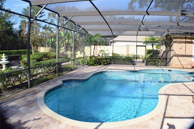 view of swimming pool featuring a lanai and a patio