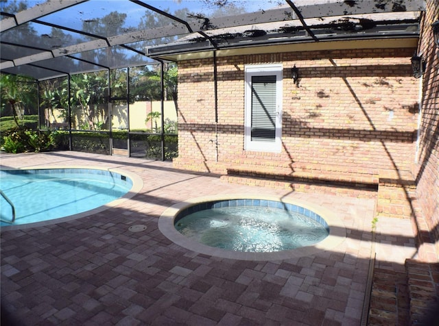 view of swimming pool with glass enclosure, an in ground hot tub, and a patio