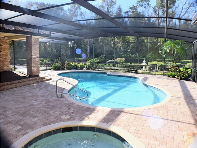 view of swimming pool featuring a patio area, a lanai, and an in ground hot tub