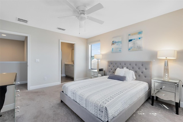 bedroom with light carpet, ensuite bath, and ceiling fan