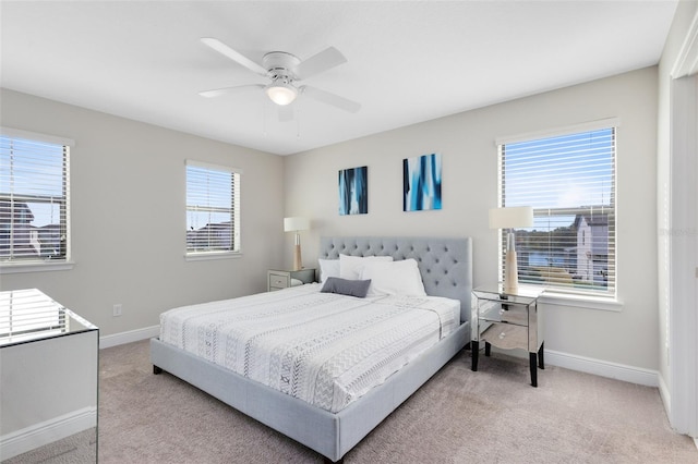 carpeted bedroom with multiple windows and ceiling fan