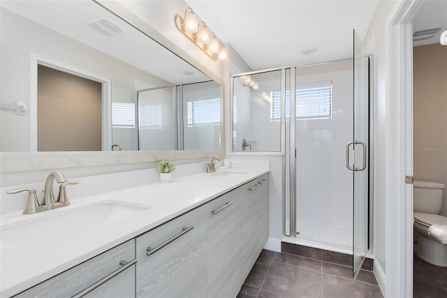 bathroom with tile patterned flooring, vanity, toilet, and an enclosed shower