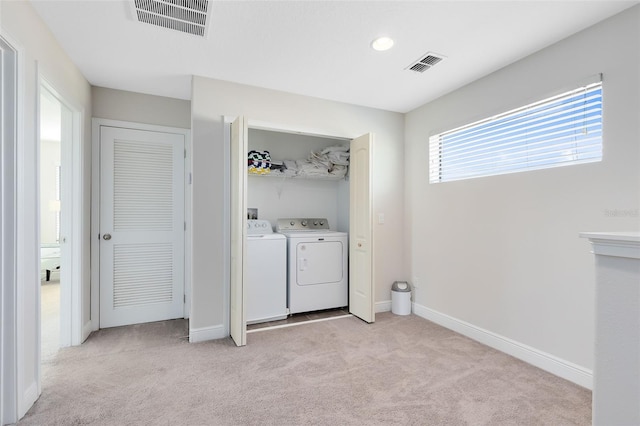 clothes washing area with washing machine and dryer and light colored carpet