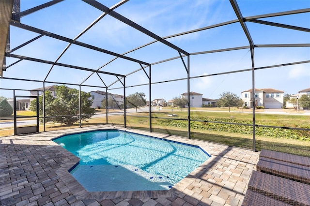 view of pool with glass enclosure and a patio area