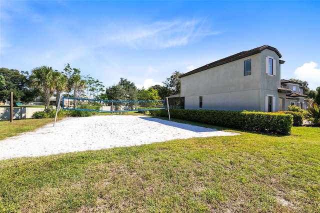 view of home's community featuring volleyball court and a lawn