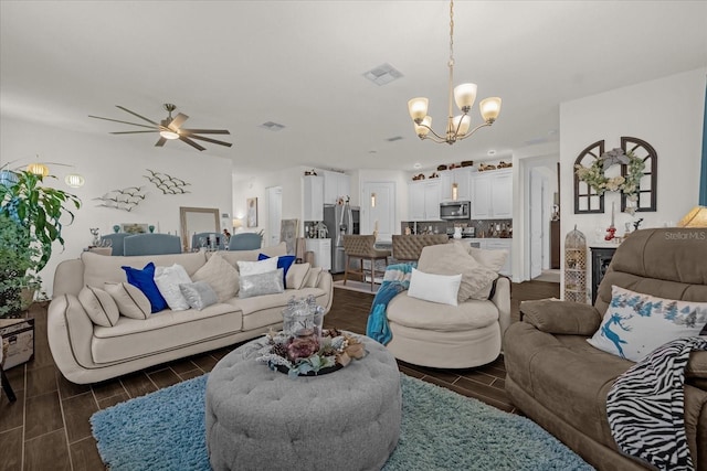 living room featuring ceiling fan with notable chandelier and dark hardwood / wood-style floors