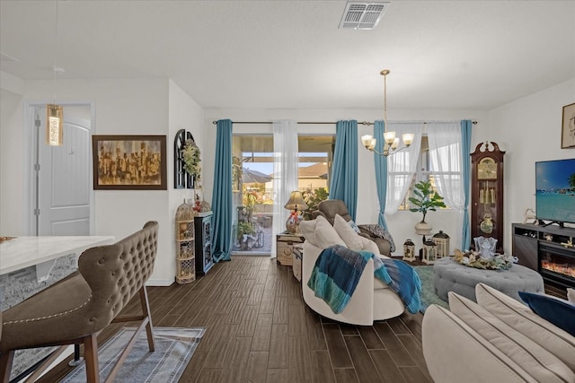 living room with dark wood-type flooring and a chandelier