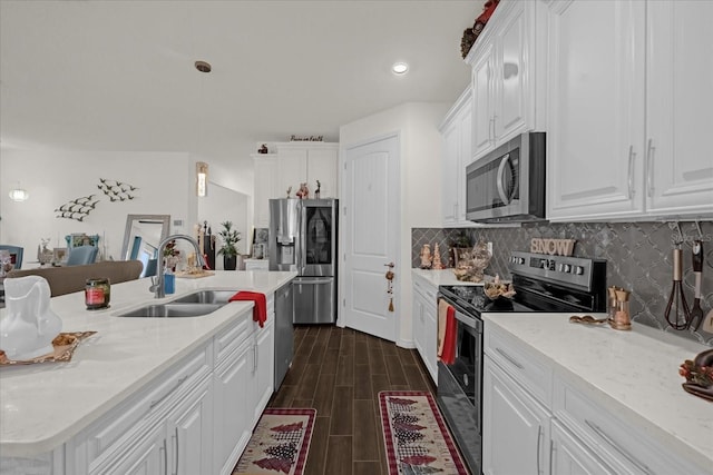 kitchen with pendant lighting, dark wood-type flooring, white cabinets, sink, and stainless steel appliances