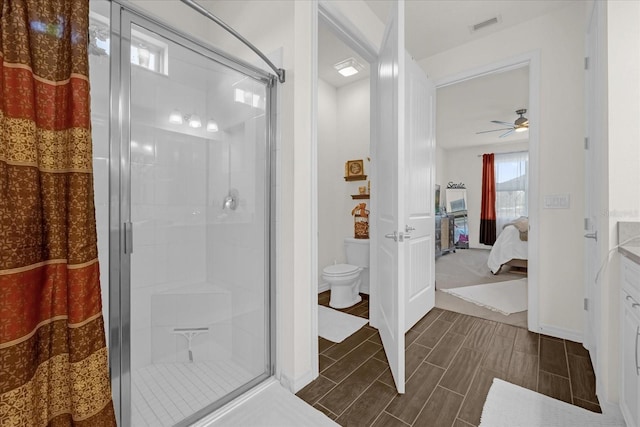 bathroom featuring an enclosed shower, ceiling fan, and toilet