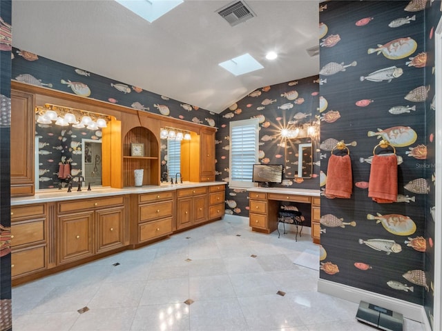 bathroom featuring vaulted ceiling with skylight, vanity, and tile patterned flooring