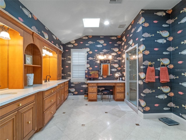 bathroom with a shower with door, vanity, and vaulted ceiling with skylight