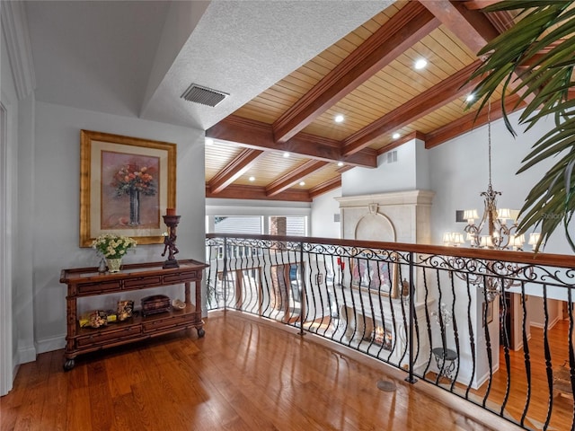 hall featuring vaulted ceiling with beams, wooden ceiling, a notable chandelier, and wood-type flooring