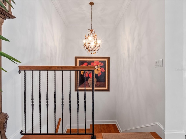 stairway featuring crown molding, wood-type flooring, and a notable chandelier