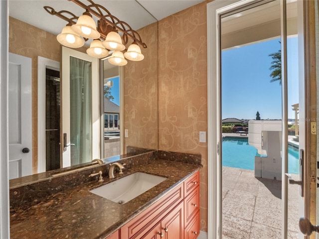 bathroom with vanity and a notable chandelier