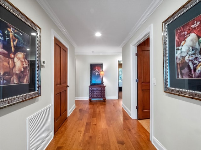 hallway with light wood-type flooring and crown molding