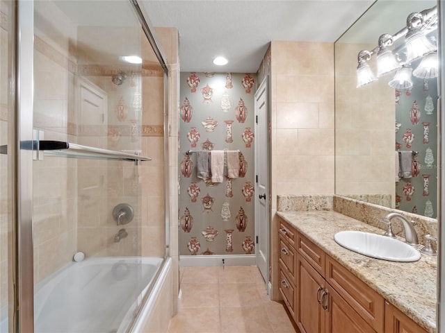 bathroom with combined bath / shower with glass door, vanity, and tile patterned flooring