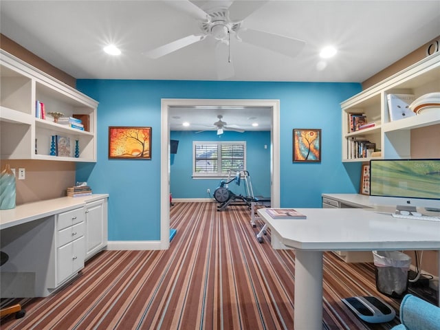 carpeted office with built in desk and ceiling fan