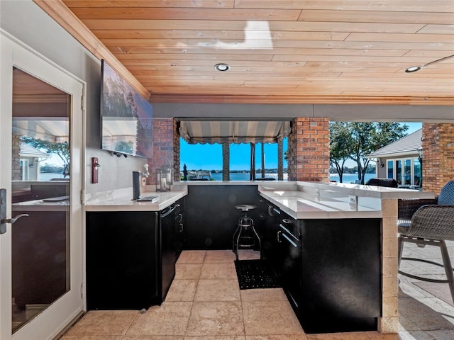 kitchen featuring a breakfast bar area, kitchen peninsula, and wooden ceiling