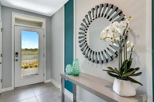 doorway with light tile patterned flooring and a textured ceiling