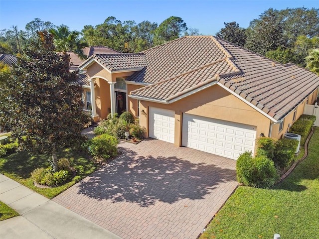 mediterranean / spanish-style house featuring cooling unit and a garage