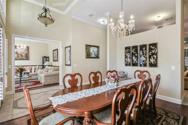 dining room with hardwood / wood-style flooring, ornamental molding, and a notable chandelier