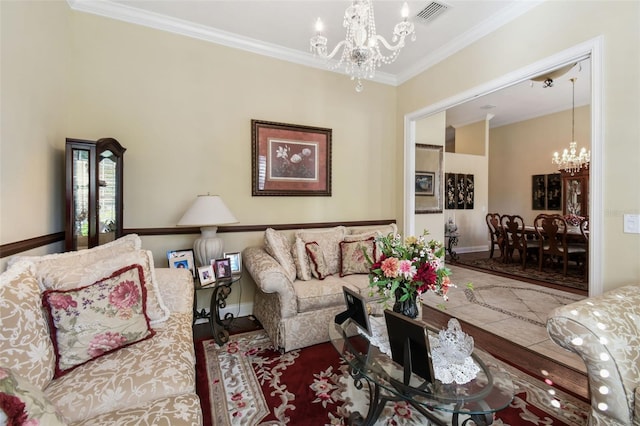 living room with hardwood / wood-style floors, a notable chandelier, and crown molding