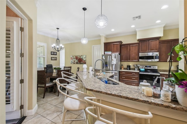 kitchen featuring stainless steel appliances, a notable chandelier, decorative light fixtures, light tile patterned floors, and ornamental molding