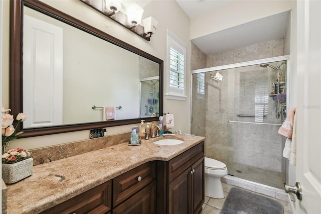 bathroom with tile patterned floors, vanity, toilet, and a shower with door