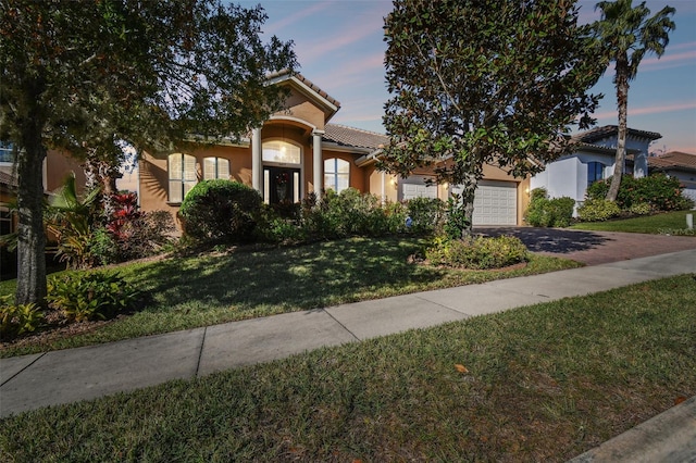 view of front of home featuring a lawn and a garage